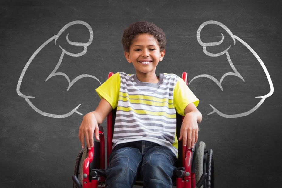 Disabled student in front of chalkboard with drawing of big strong arms flexing as if they were his arms