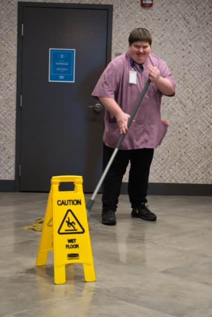 Young man with disabilities mopping the floor
