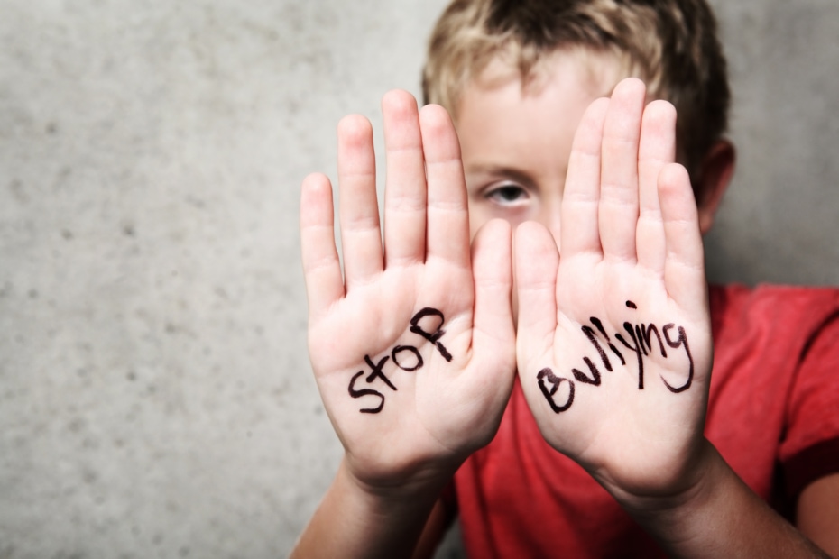 Kid with hands up which have Stop Bullying written on them