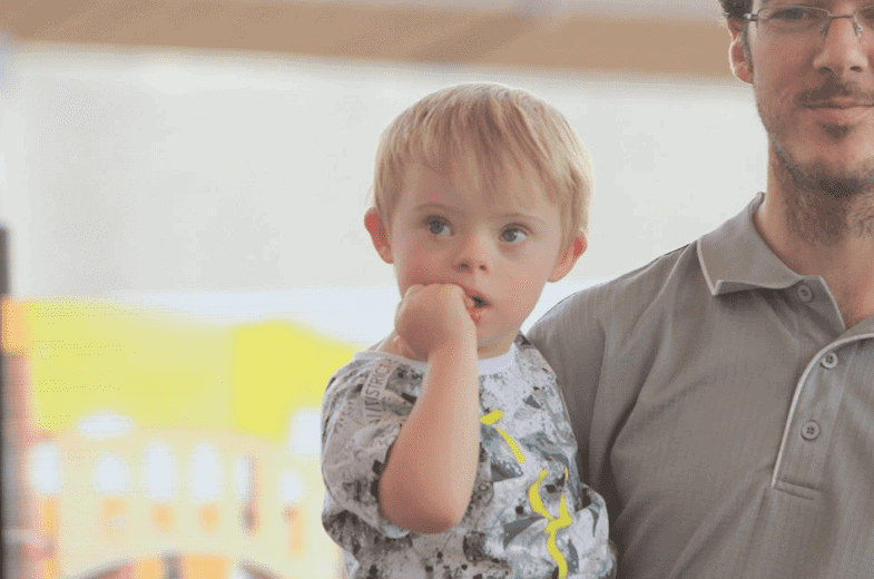 Father holding son with Down Syndrome